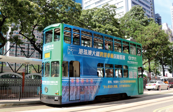 載有太平香港跨境車輛保險服務的宣傳特色電車在香港島行駛。